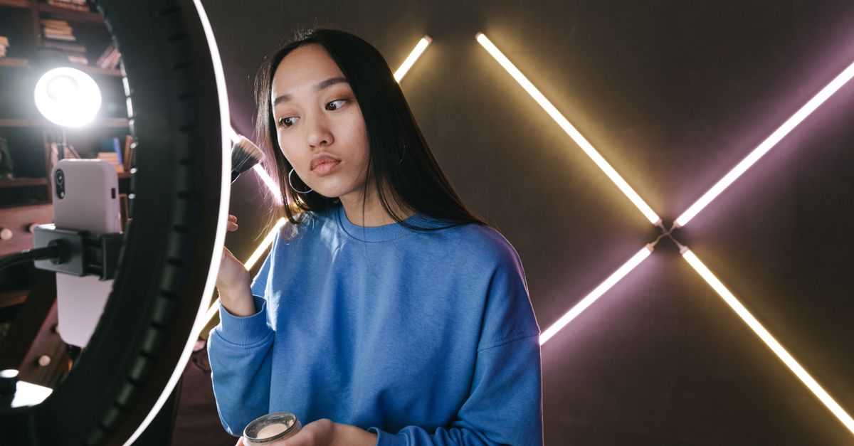Creator on camera with ring light and neon studio backdrop